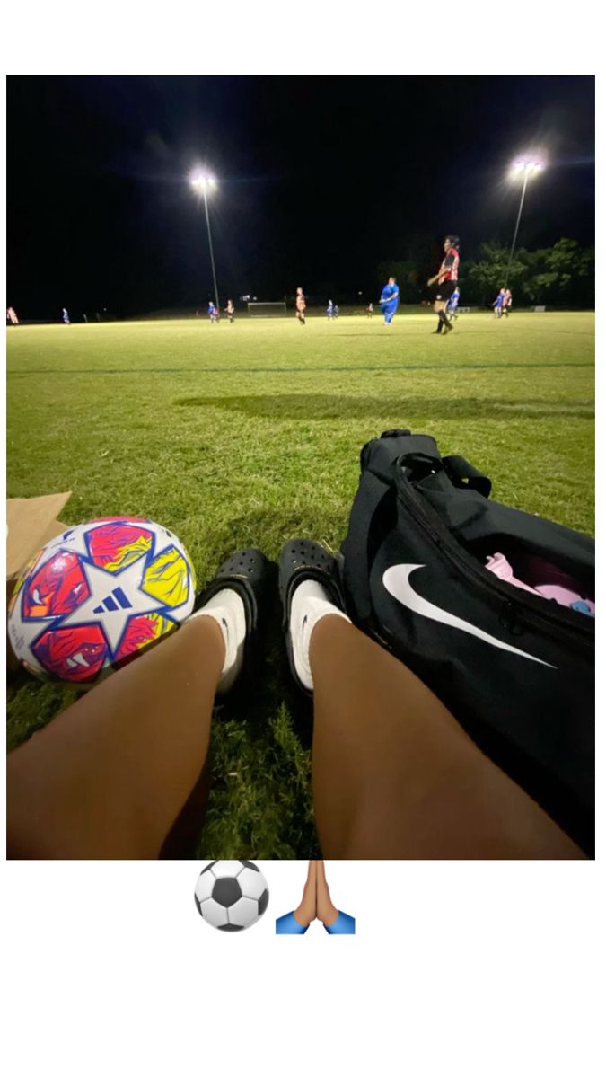 a person is sitting on the grass with a soccer ball