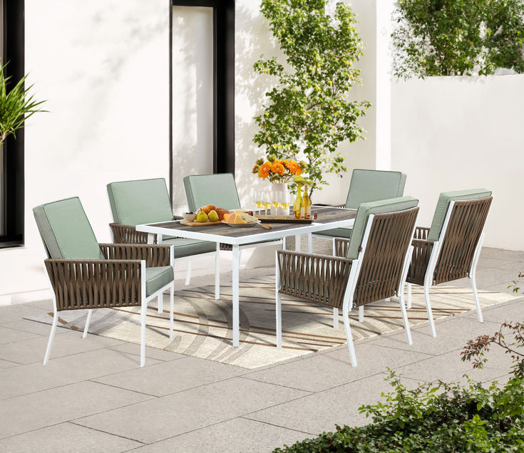 an outdoor dining table and chairs set up on a patio