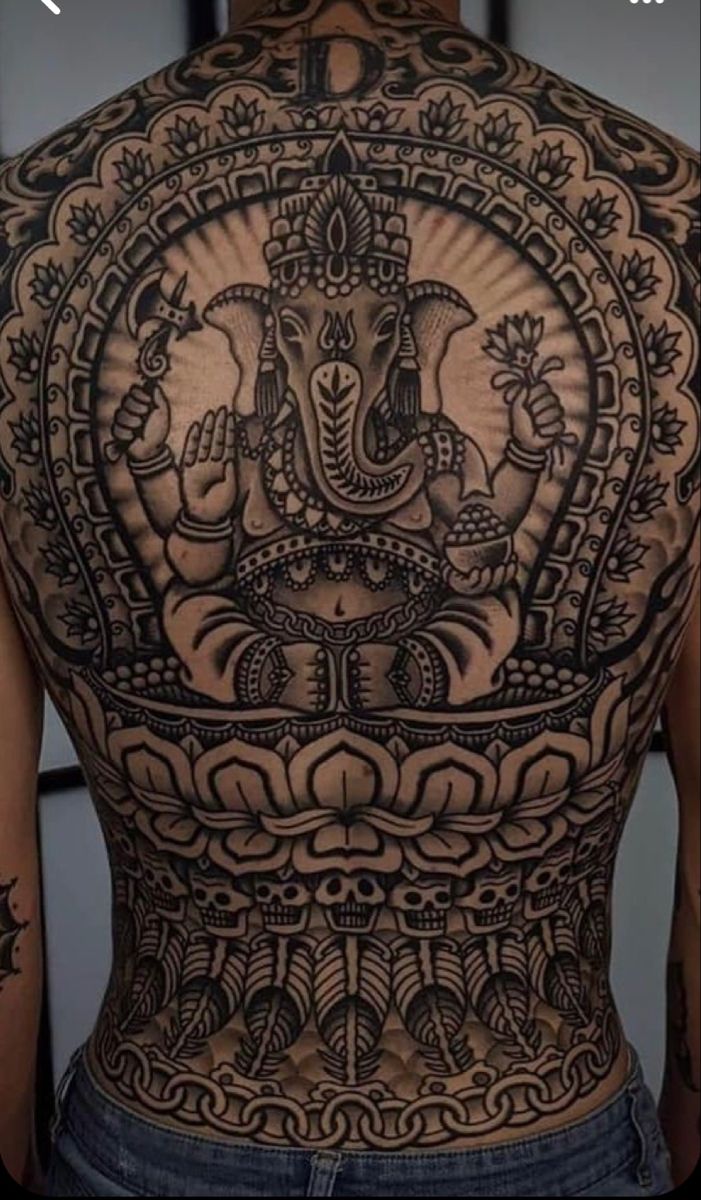 the back of a man's body with tattoos on it and an elephant in the middle