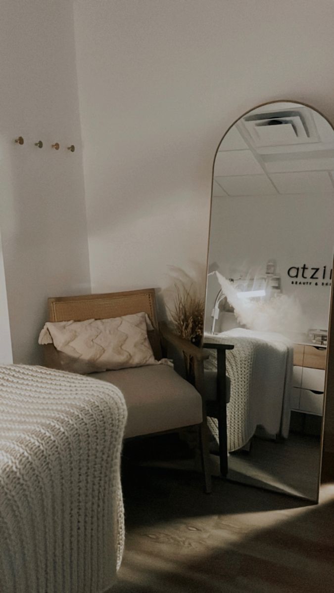 a bed sitting next to a mirror in a bedroom