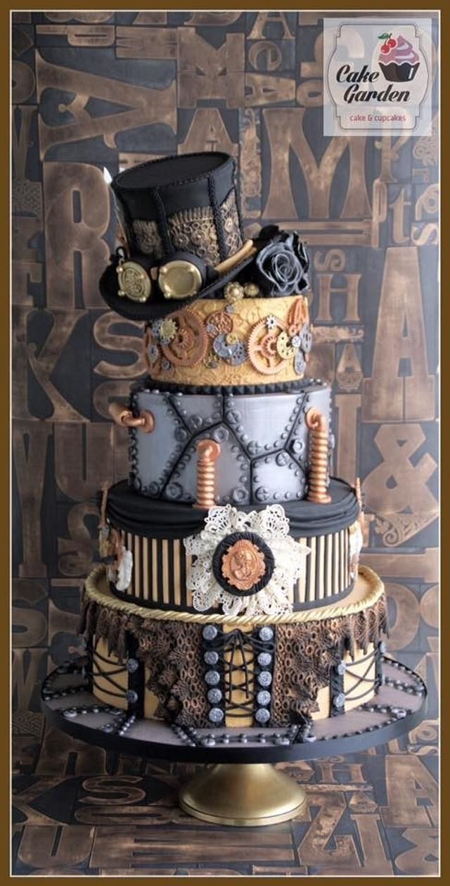 a three tiered cake is decorated with steampunk and gears, including a top hat