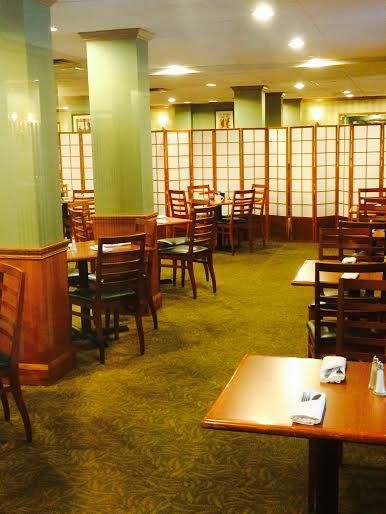 an empty restaurant with tables and chairs in the middle, green carpeted flooring