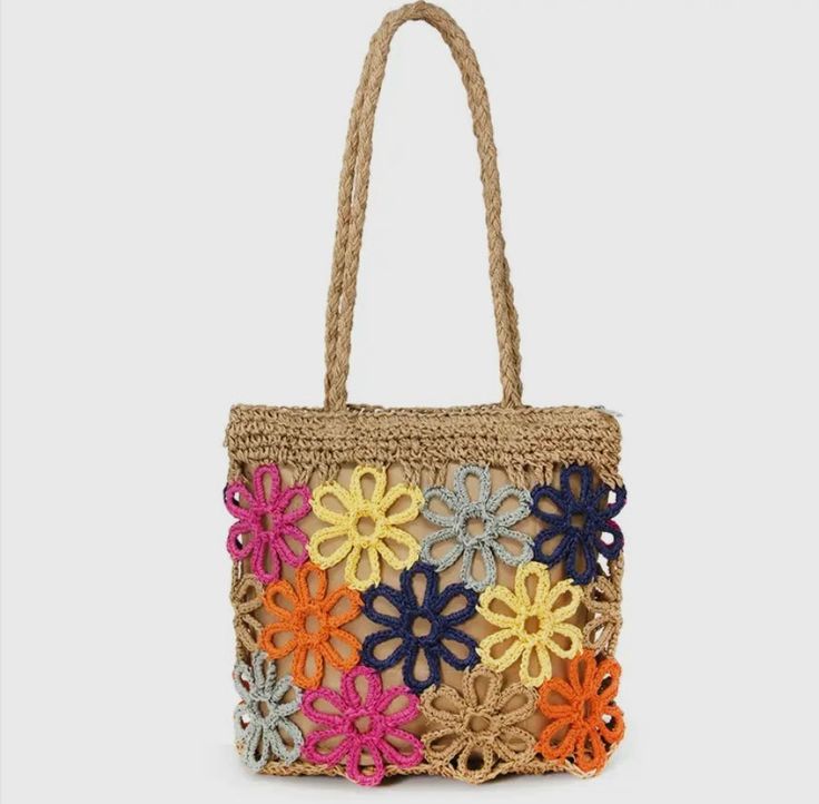 a multicolored crocheted bag with flowers on the front and bottom, hanging from a rope