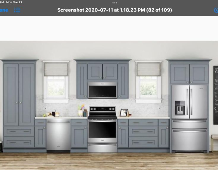 a kitchen with gray cabinets, white appliances and wooden floors is shown in this image