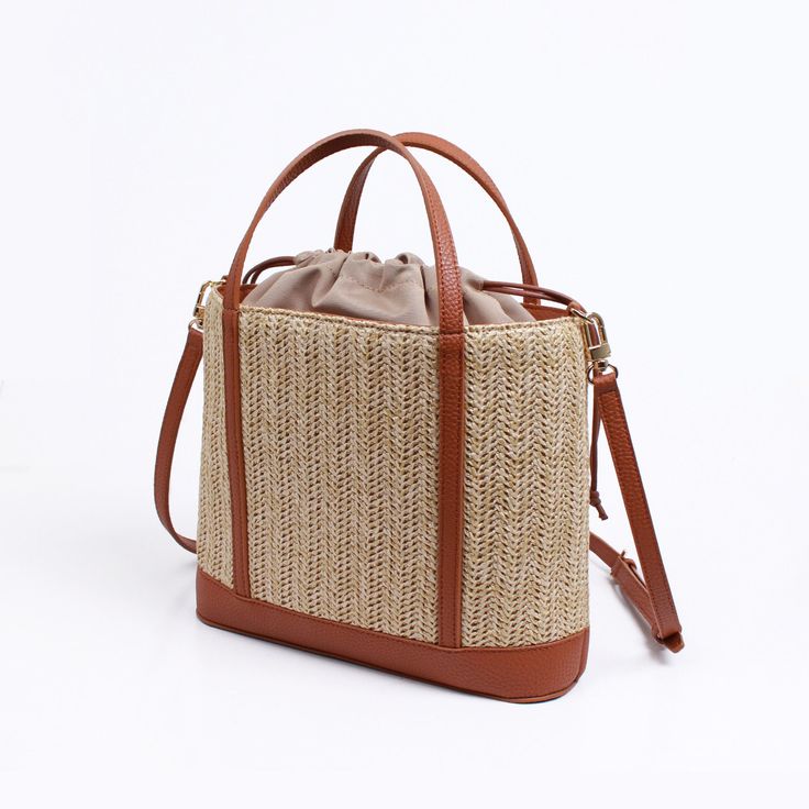 Made from high quality Raffia. Vegan leather trim. Polyester lining. Our raffia line are all made with an interior liner to keep your items safe and enclosed from beach sand or any harsh environment. Great size for traveling and for the summer heat.  Has 2 interior pockets for organization.  Dimensions: 260x220X75mm Weight:  368g (bag) SHIPPING:  Free shipping from South Korea, estimated 7-14 days to get to you from purchase date.  RETURNS:  Return address is in USA so that returns can be made and given fast.  Returns up to 2 weeks starting when the shipping is completed.  Returns must be with tags.  Buyer must pay for return shipping unless item was damaged or incorrect.  Money will be refunded after we receive and inspect the item. Orders over $250 will have to pay 20% restocking fee. Light Brown Beach Bag With Leather Handles, Spring Travel Bucket Bag In Natural Fiber, Summer Beige Shoulder Bag With Leather Handles, Woven Light Brown Vacation Bags, Rectangular Beige Bucket Bag With Leather Handles, Woven Light Brown Bags For Vacation, Beige Rectangular Bucket Bag With Leather Handles, Beige Straw Bag With Woven Leather Top Handle, Summer Bucket Bag With Braided Handles For Everyday