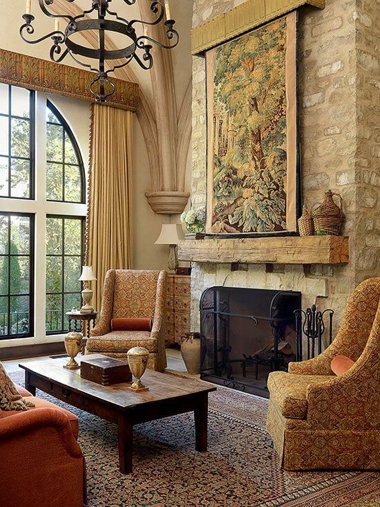 a living room filled with furniture and a fire place under a chandelier in front of a window