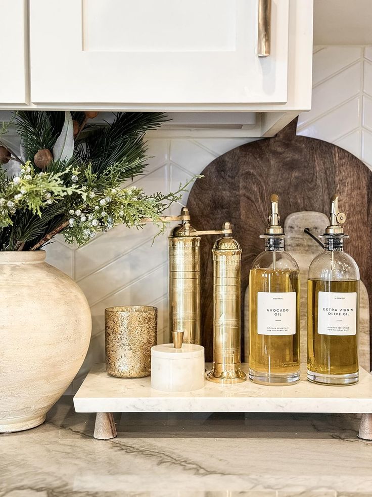 some bottles are sitting on a shelf in the kitchen next to a potted plant