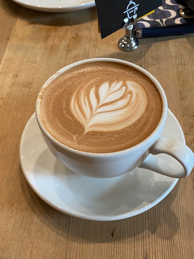 a cappuccino on a saucer with a leaf design