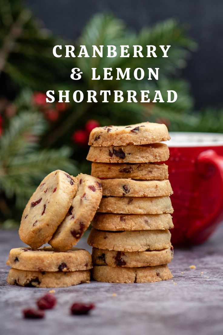 a stack of cranberry and lemon shortbread cookies next to a bowl of cranberries