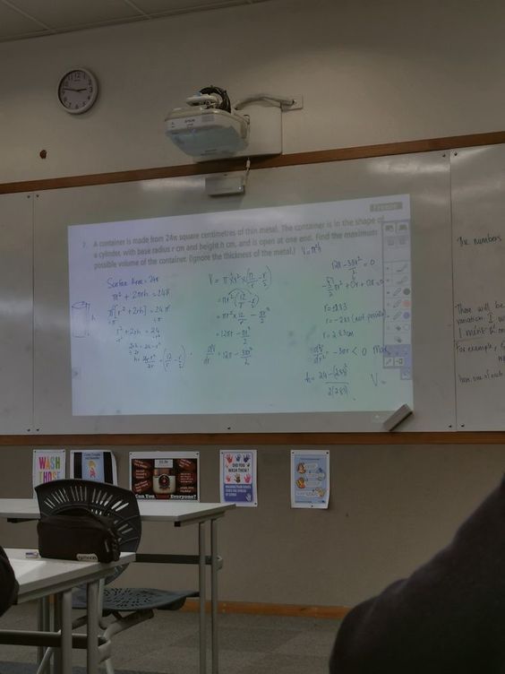 a man standing in front of a whiteboard with writing on it