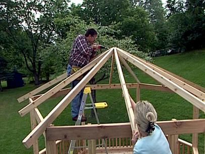 two people are constructing a wooden structure in the yard