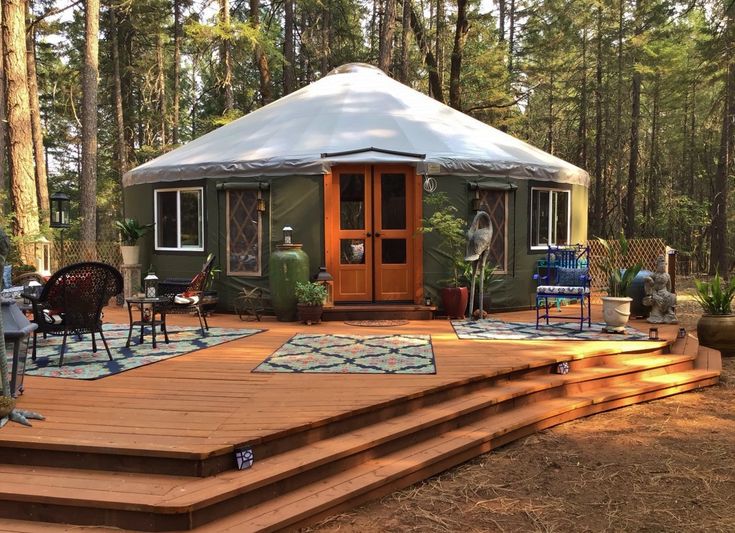 a yurt in the woods with steps leading up to it