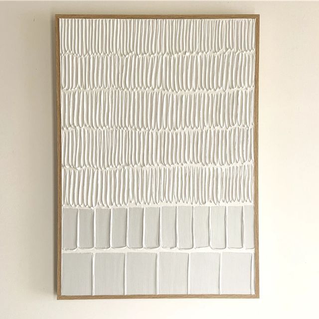 a white painting hanging on the wall