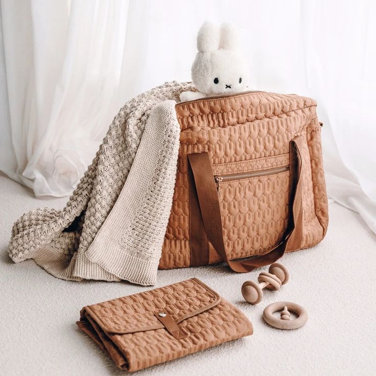 a brown bag sitting on top of a white floor next to doughnuts and a blanket