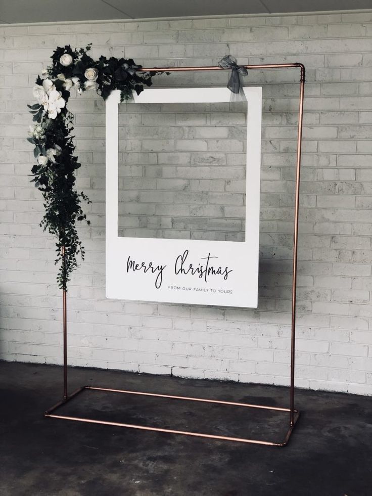 a sign that says merry christmas hanging on a wall next to a potted plant