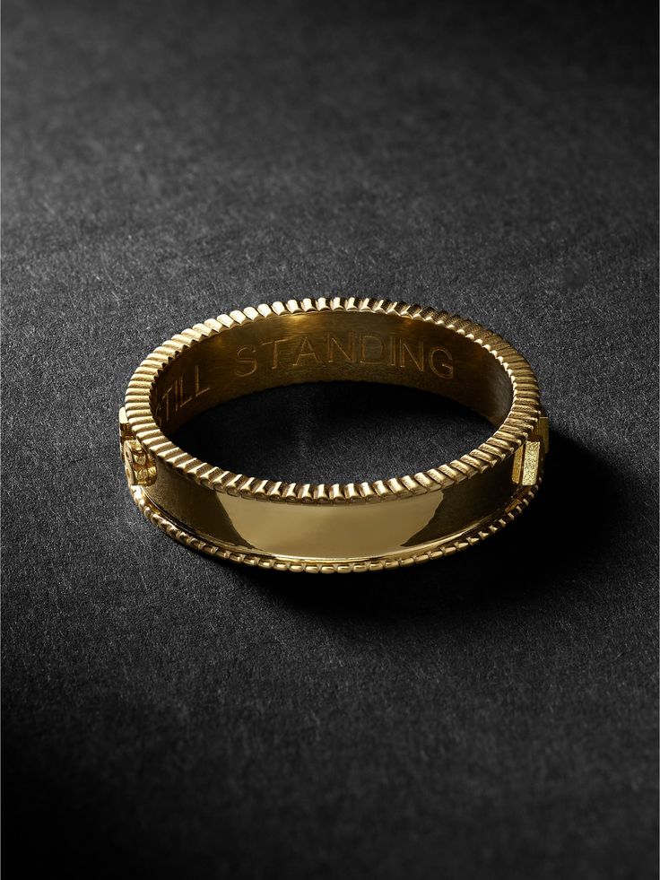 There's always a clear meaning to Foundrae's jewellery. This ring is handcrafted from 18-karat gold and embossed with adhuc stantes which is Latin for 'still standing', serving as a reminder of your strength and fortitude. Designer Gold Rings With Polished Finish, Designer Gold Ring With Polished Finish, Designer Polished Gold Rings, Luxury Gold Engraved Ring, Luxury Yellow Gold Engraved Ring, Luxury Hallmarked Jewelry With Round Band, Luxury 14k Gold Jewelry With Decorative Band, Designer 14k Gold Rings With Polished Finish, Designer Polished 14k Gold Rings