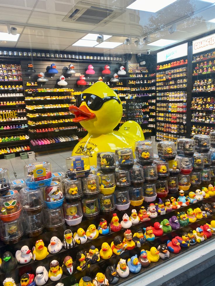 there is a yellow rubber ducky in the middle of this store display with lots of toys