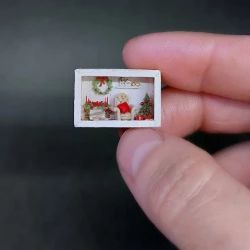 a miniature christmas scene is being held in someone's hand with a tiny ring on it