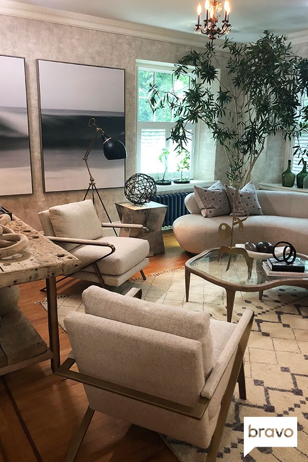 a living room filled with furniture and a chandelier above a glass top table