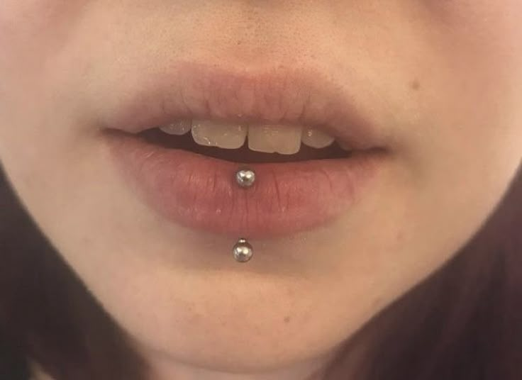 a woman's lips with a nose piercing on top of her lip and the bottom part of her mouth