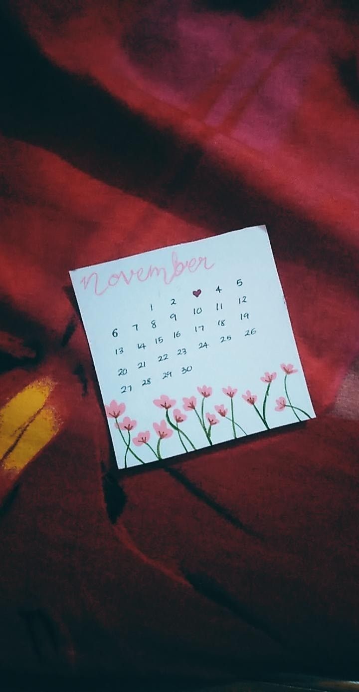 a calendar pinned to a red blanket with flowers on it