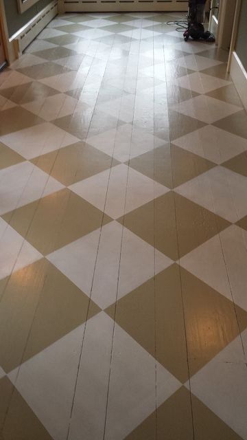 an empty hallway with checkered flooring and two doors on the other side that leads to another room