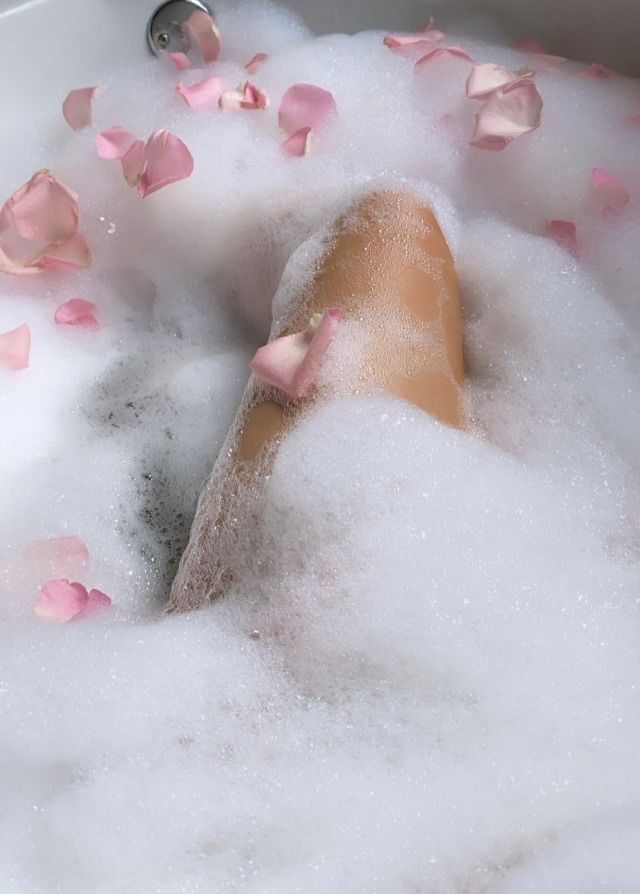 a bathtub filled with foam and rose petals