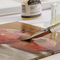 a paintbrush sitting on top of a piece of wood