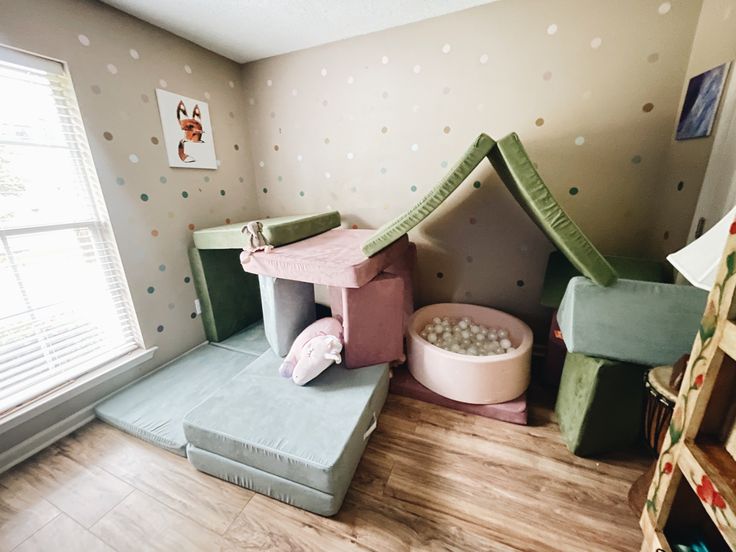 a child's play room with toys in it and a cat house on the floor