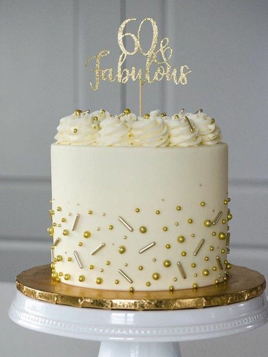 a white cake with gold sprinkles and a 60th birthday sign on top