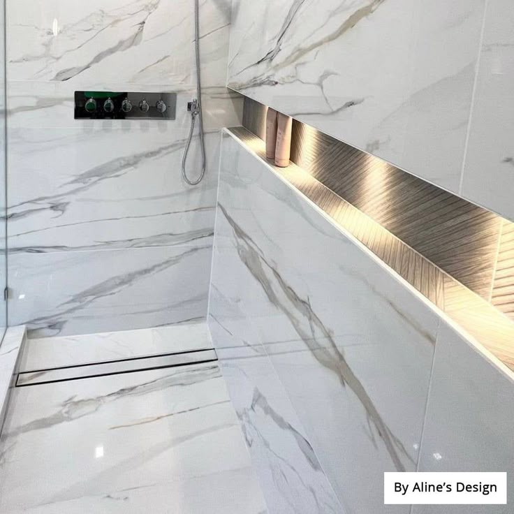 a bathroom with white marble walls and flooring next to a walk in shower area