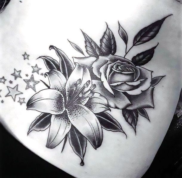 a black and white tattoo with flowers on the side