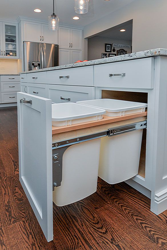 a kitchen with white cabinets and two sinks in the center, an island is built into the floor