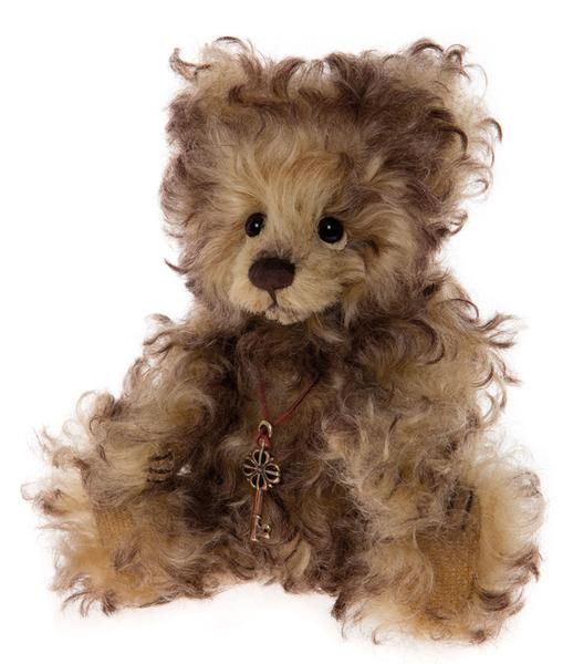 a brown teddy bear sitting on top of a white floor next to a keychain