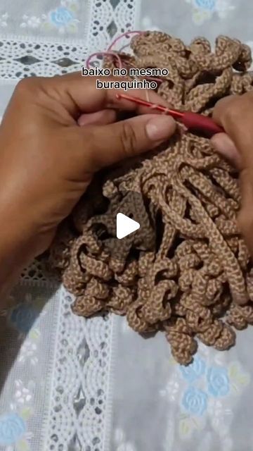 two hands crocheting together on a table