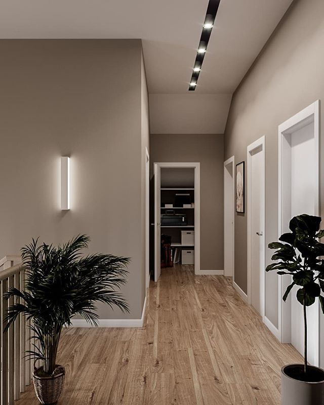 an empty hallway with a potted plant on the floor