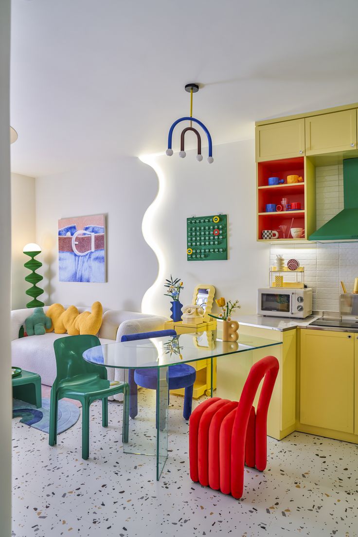 a colorful kitchen and dining area with yellow cabinets, white walls, and flooring