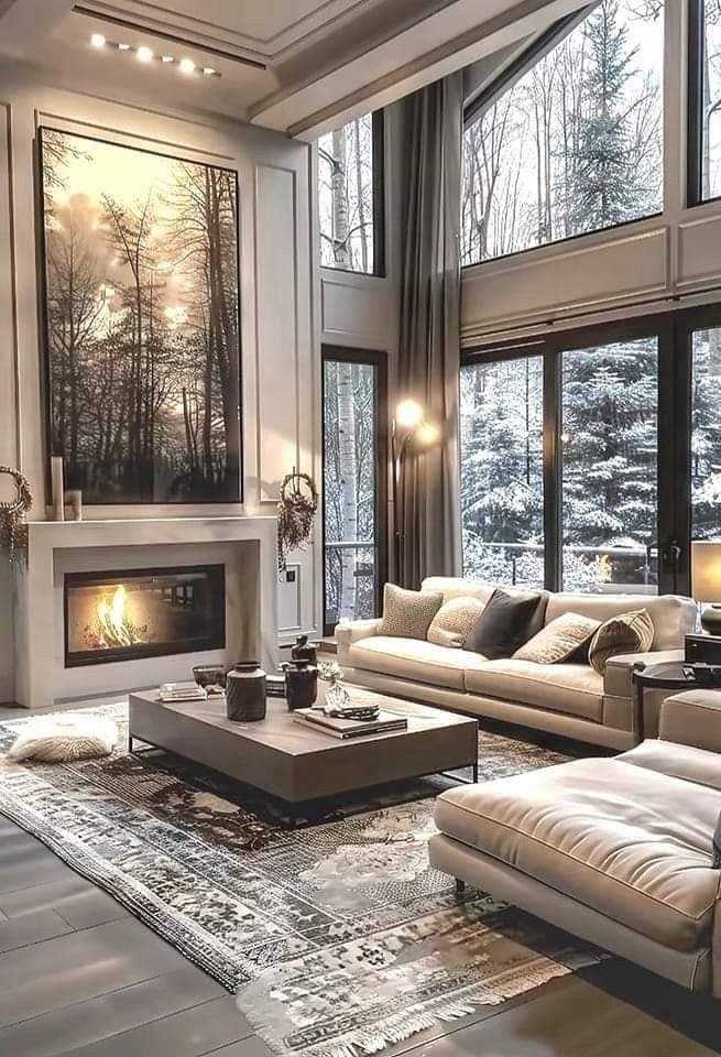 a living room filled with furniture and a fire place in front of a large window