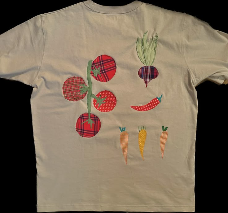 a white t - shirt with carrots and radishes drawn on it's chest