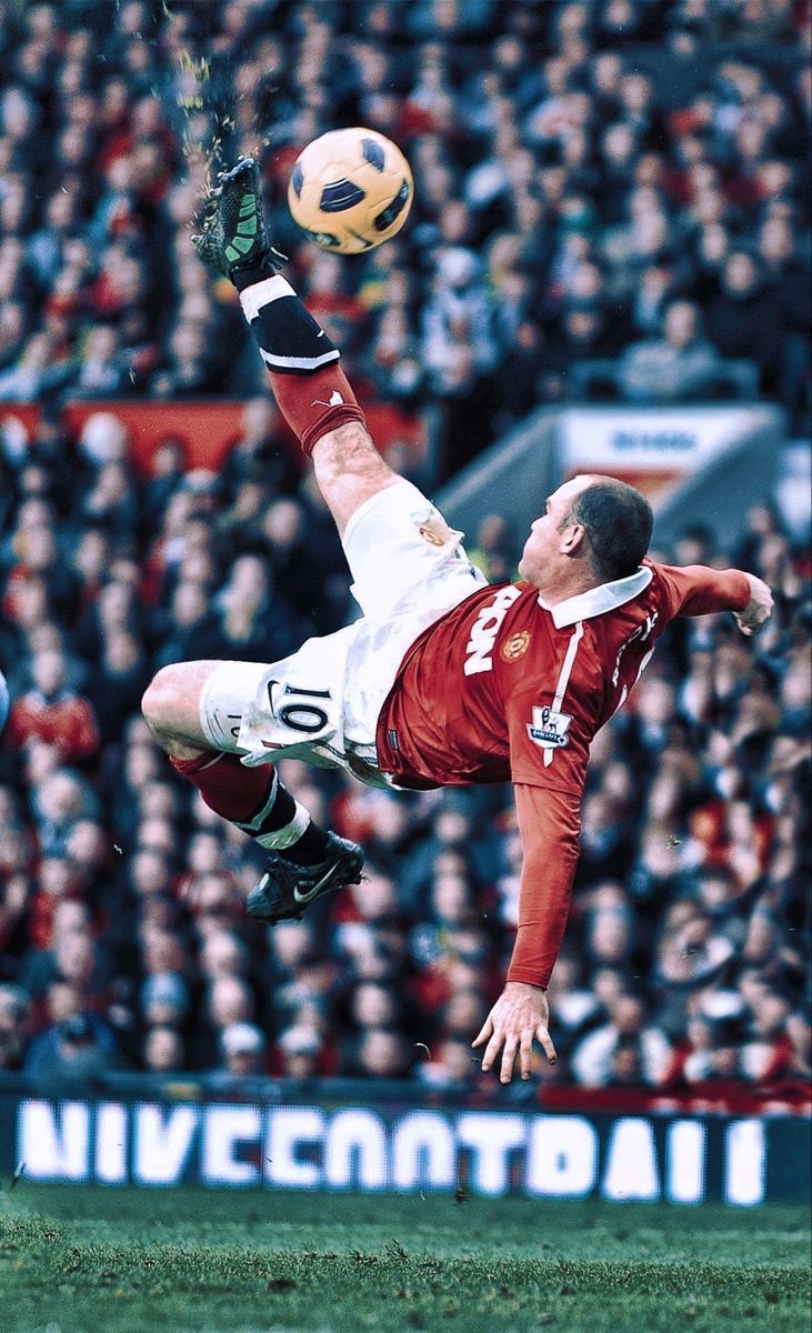 a soccer player is in mid air with the ball above his head as he kicks it