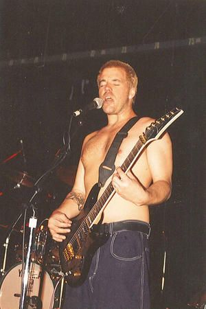 a man with no shirt on playing guitar