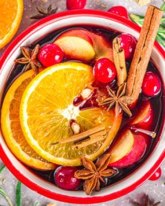 a bowl filled with orange slices, cinnamons and other fruit on top of a table