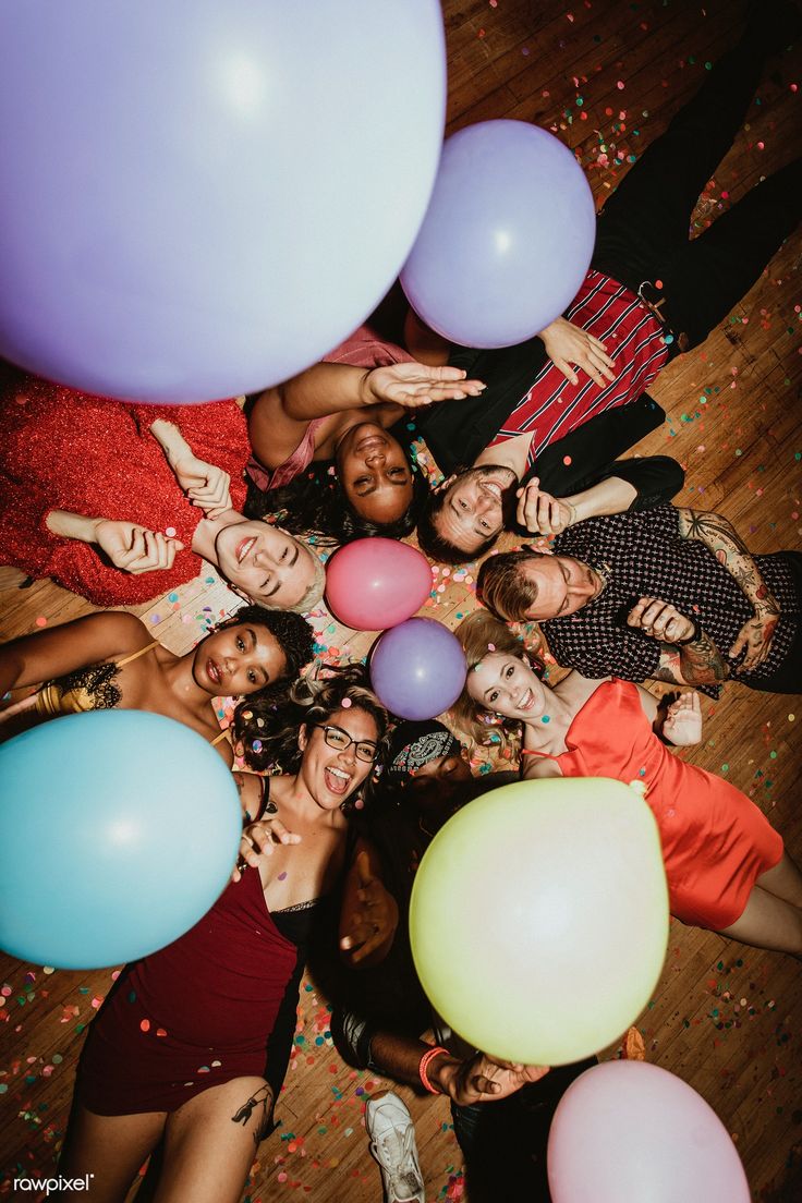 a group of people standing next to each other with balloons