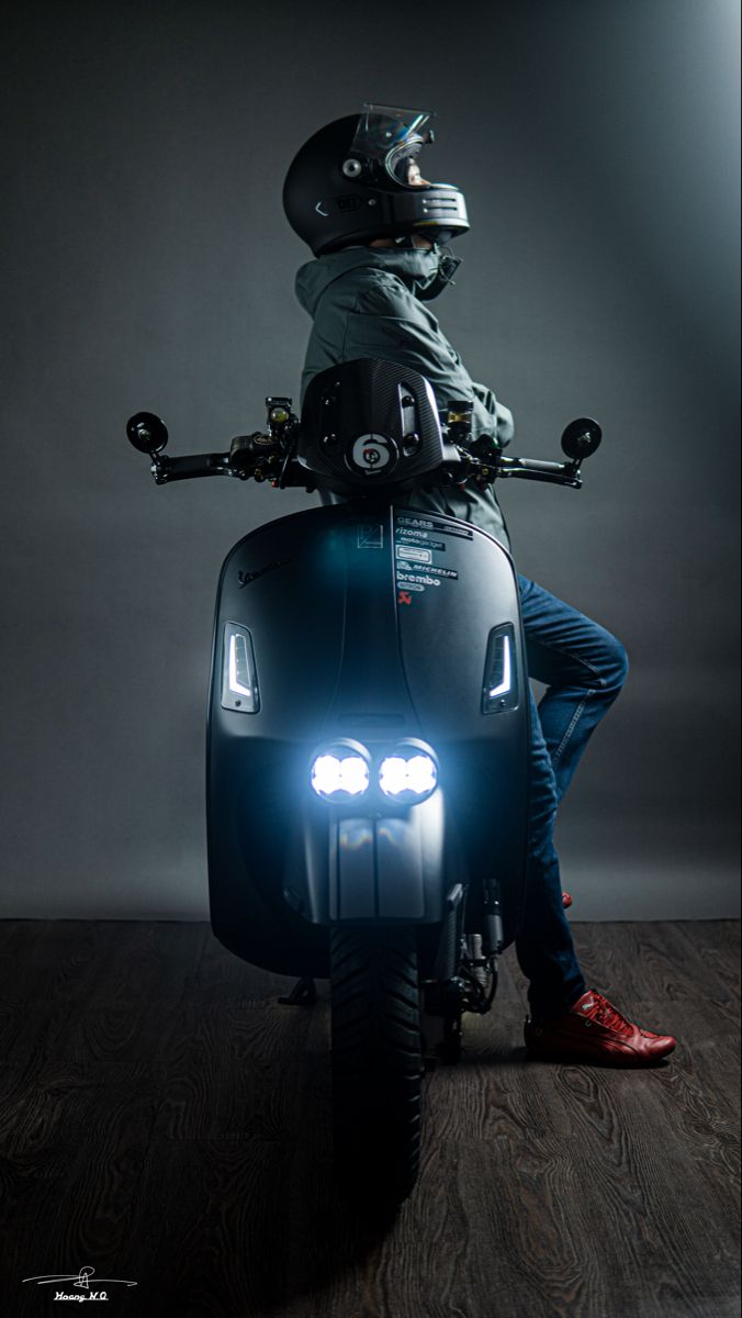 a man riding on the back of a scooter wearing a helmet and goggles