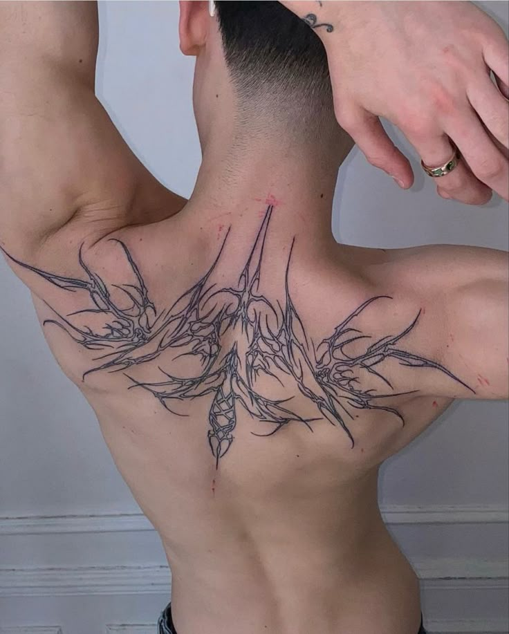 the back of a man with tattoos on his chest