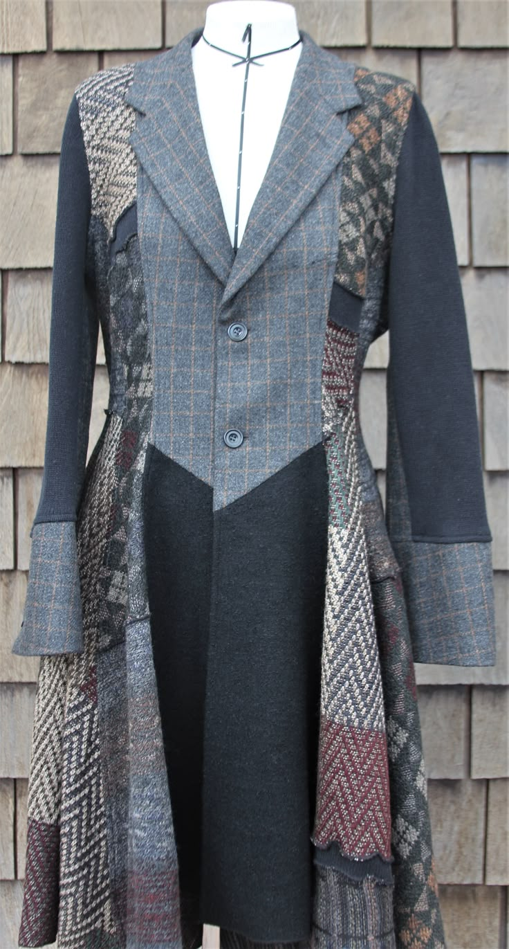 a coat with different colors and patterns on it, sitting on a mannequin