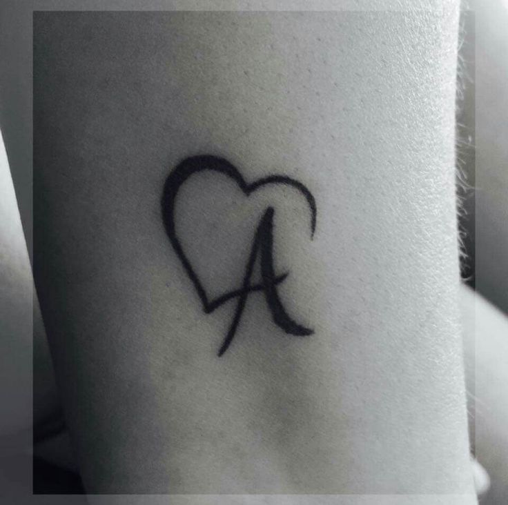 a heart tattoo with the letter a in it's center and an arrow at the bottom