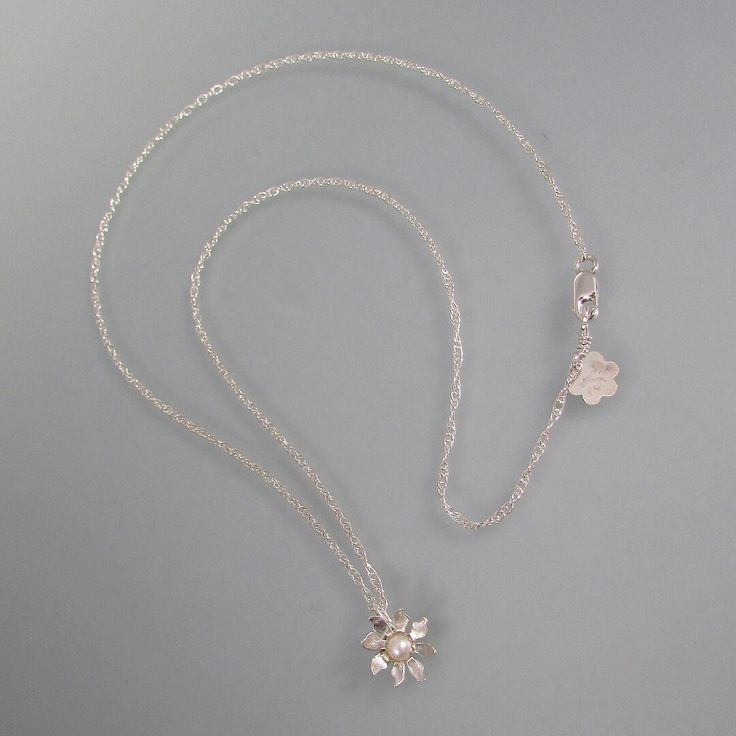 Feminine and dainty, this sculpted wildflower pendant necklace is perfect for every day wear. A simply elegant flower is hand-sculpted from recycled sterling silver and set with a 3.5-4mm round cultured freshwater pearl in a serrated bezel setting. The wildflower glides freely on your choice of an 18 or 20-inch slim sterling silver rope chain with a lobster claw clasp. Delicate White Gold Flower Pendant Necklace, Dainty White Gold Flower Pendant Necklace, Sterling Silver Flower Necklace In White Gold, Delicate Sterling Silver Flower Pendant Jewelry, Delicate Sterling Silver Flower Necklace For Wedding, 14kt Gold Jewelry, Necklace With Pearl, Silver Rope Chain, Flower Charm Necklace