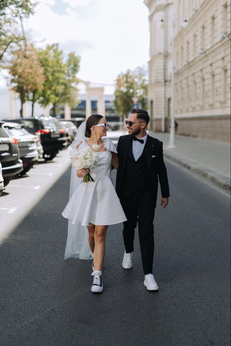 a bride and groom walking down the street