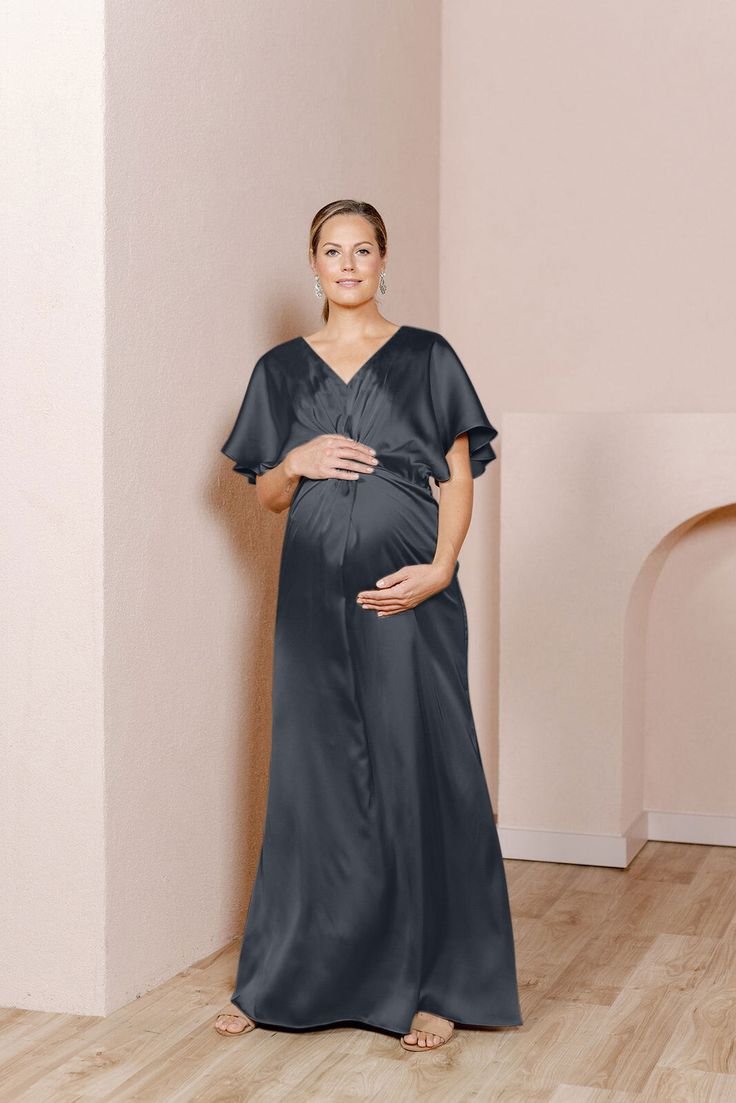 Our graceful Gwen Satin dress has been modified with a higher waistline and extra room to accommodate a growing bump, becoming the perfect option for the mommy-to-be in your bridal party! While a little more modest in coverage, the Gwen still features flutter sleeves and a delicate front twist detail that adds sophistication to a timeless design. FEATURES: Empire silhouette V-neckline Built-in bra cups and vertical boning for support Dolman flutter sleeves Back zipper Full-length double lining f Elegant V-neck Maternity Gown, Elegant Nursing Friendly V-neck Dress, Elegant Maternity Dress Nursing Friendly, Elegant Nursing-friendly Maternity Dress, Elegant Short Sleeve Maternity Dress Bump Friendly, Elegant Maternity Gown With V-neck, Elegant Maternity V-neck Gown, Elegant V-neck Bump-friendly Dress, Elegant V-neck Bump Friendly Dresses